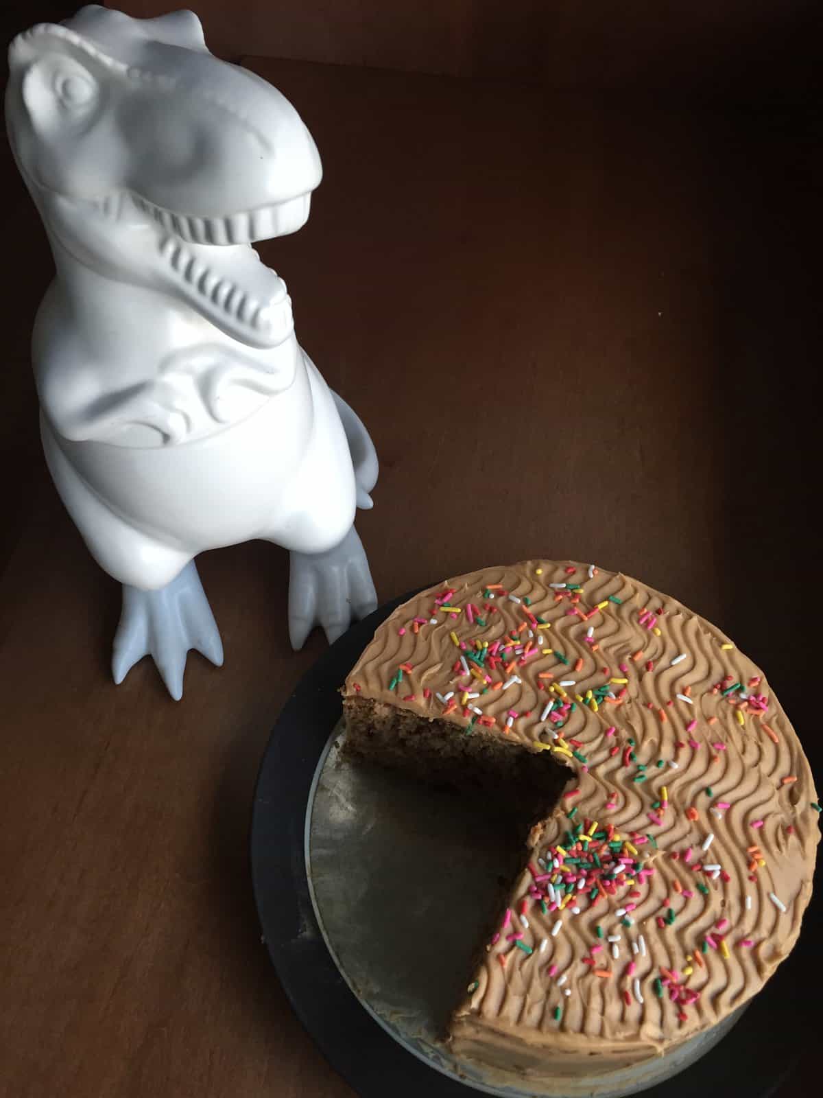 a dinosaur cookie jar overlooking Kate's apple toffee cake.