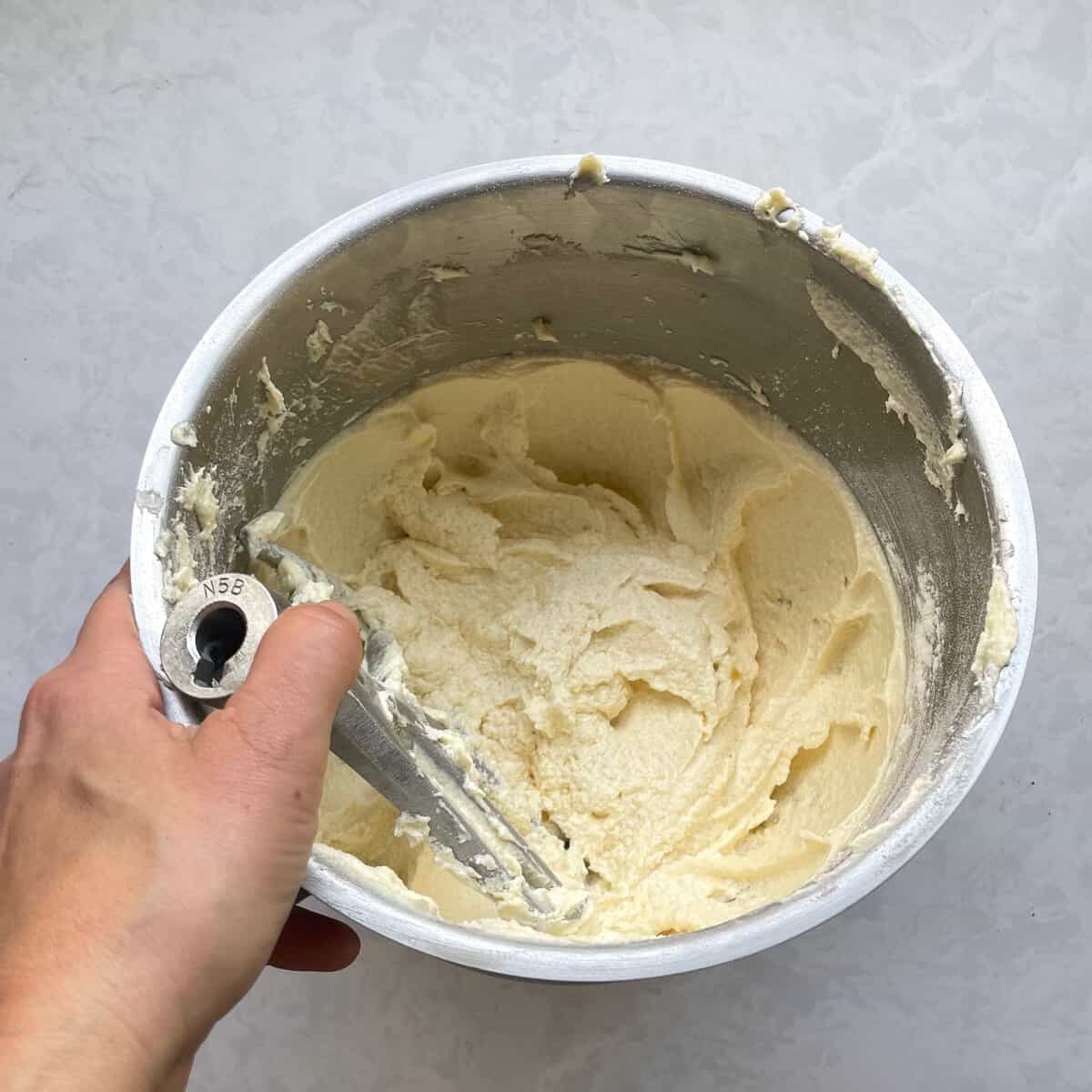 mixing bowl with white batter and paddle.