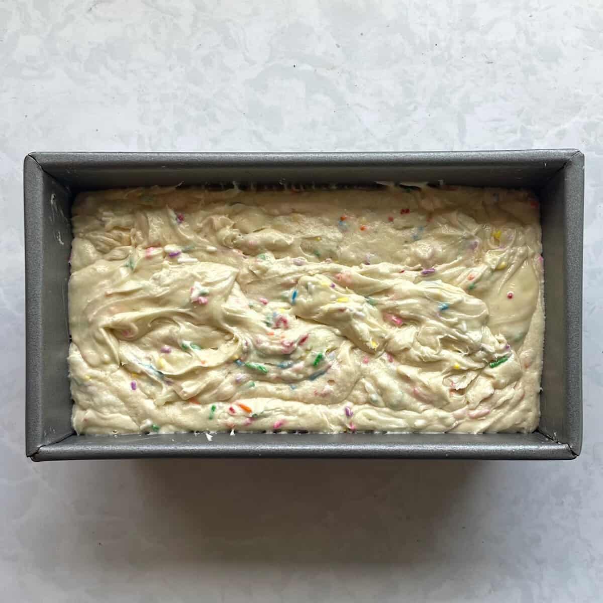 unbaked funfetti cake in a loaf pan.