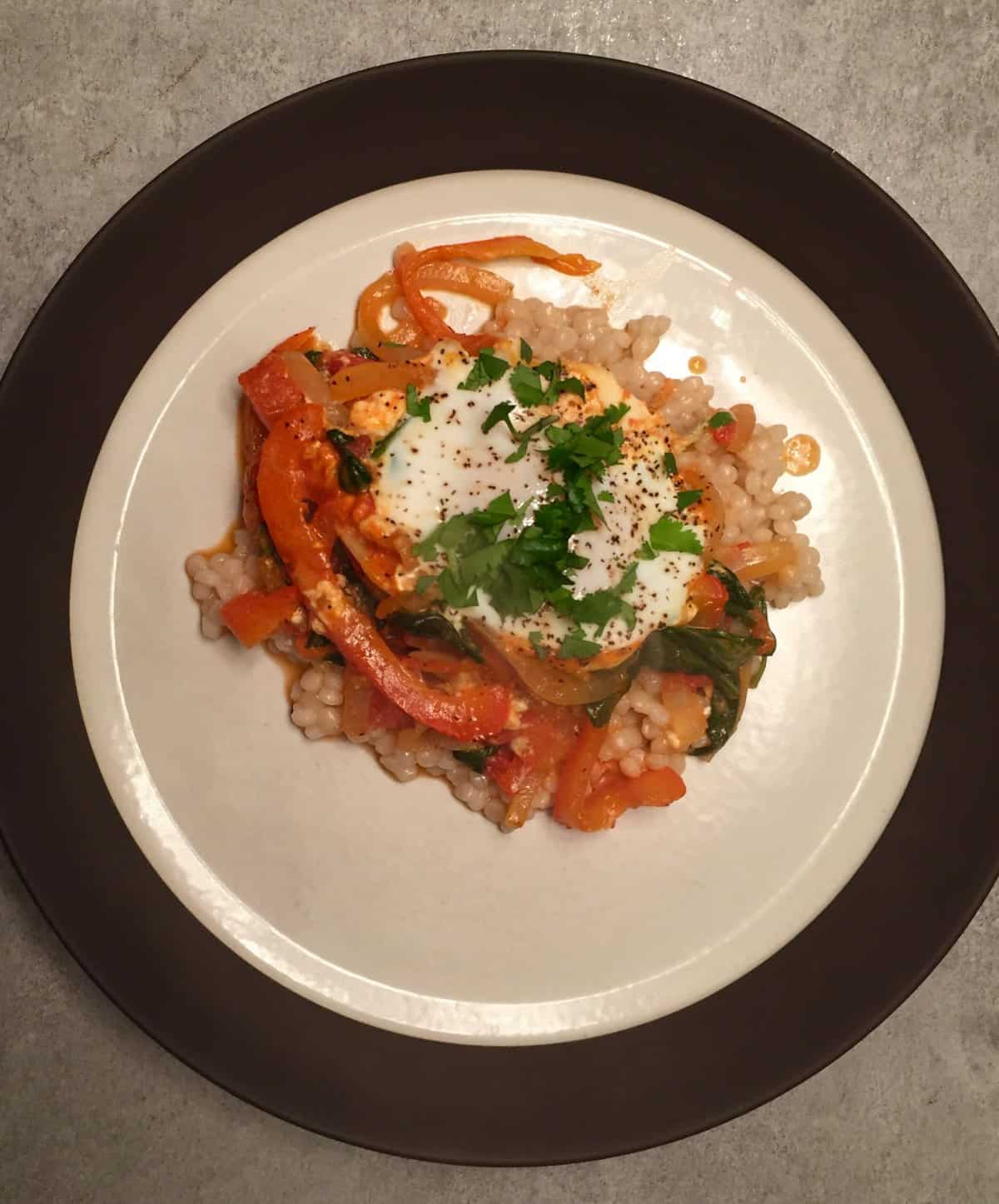 Israeli couscous and plate of shakshuka for one person.