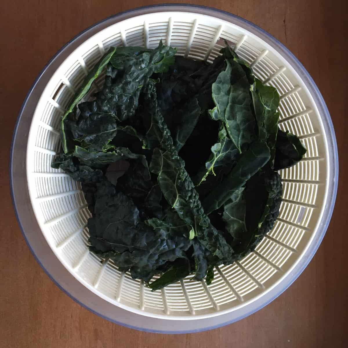a salad spinner filled with kale leaves.