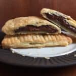 whole pop tart and two pop tart halves on a plate showing creamy brown filling inside.