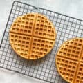 two orange waffles on a cooling rack.