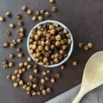 overflowing bowl of roasted chickpeas and wooden spoon.
