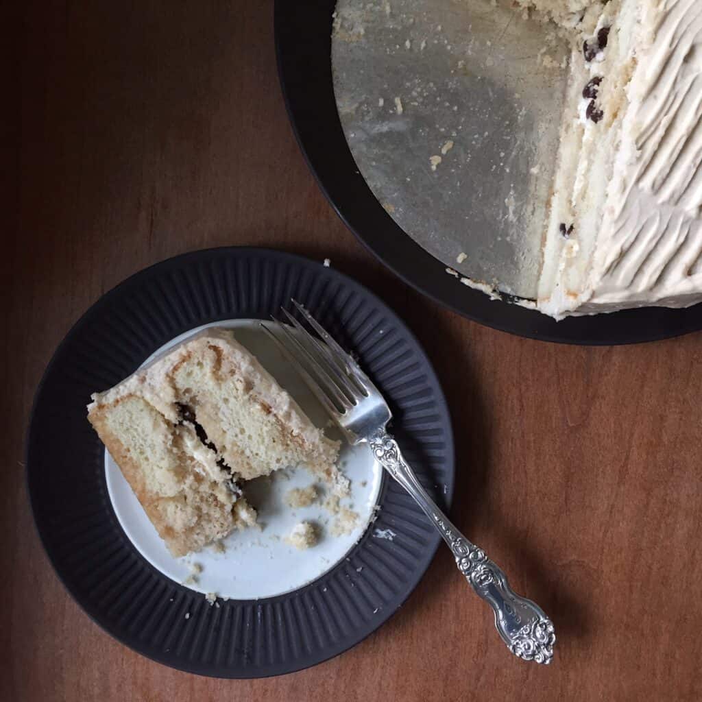 a slice of tiramisu cake on a plate next to the cake.
