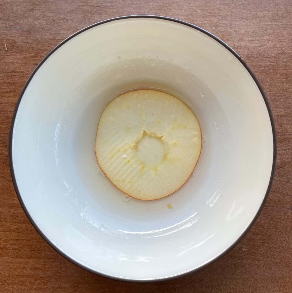 apple ring in a bowl of lemon juice and water.