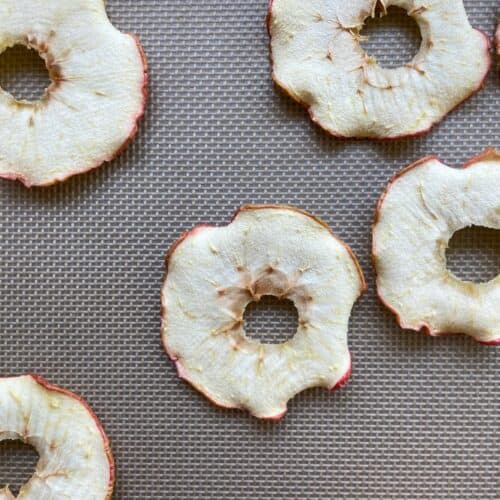 a baking sheet with dri.ed apple rings.
