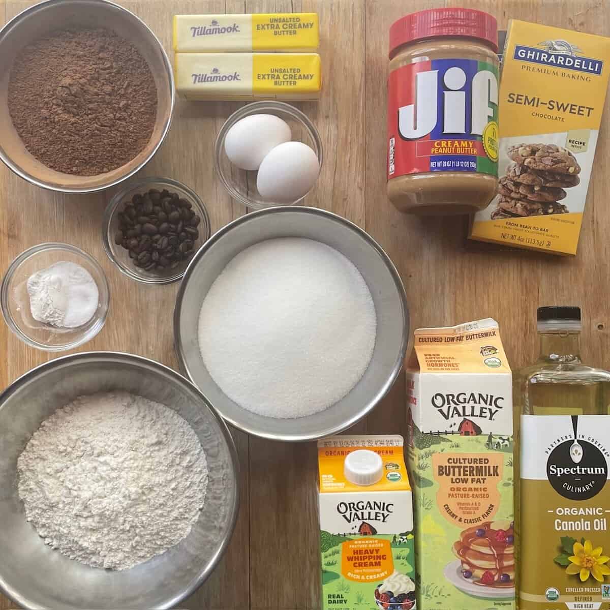 chocolate, peanut butter, cocoa, cream, butter, eggs, flour, sugar, oil, vanilla, salt and baking soda in a bowl.