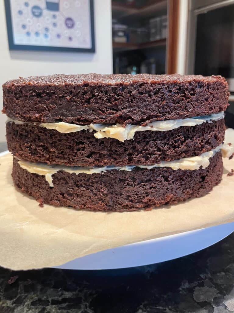 three layers of chocolate cake filled with peanut butter cream cheese frosting.