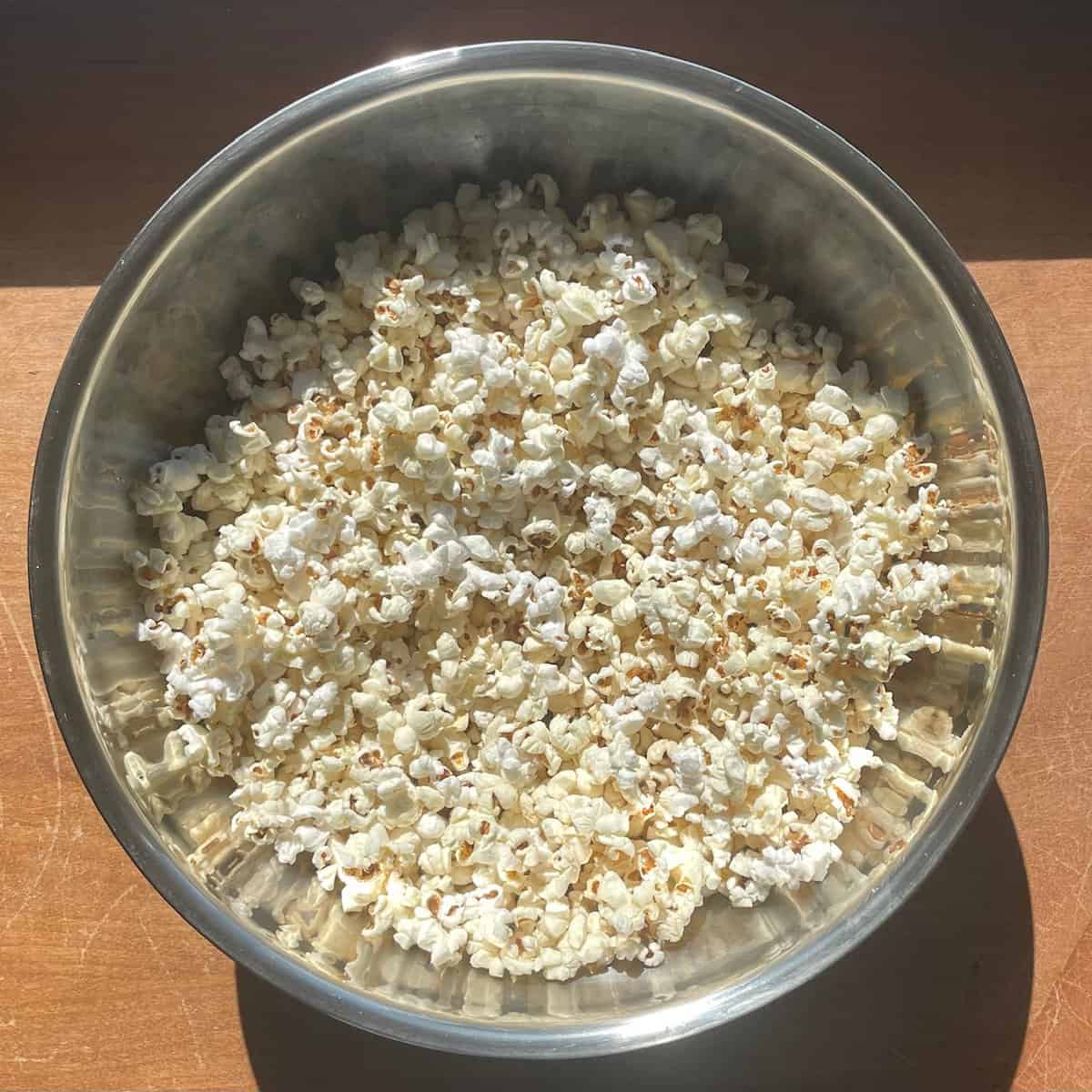 popped popcorn in a large metal bowl.