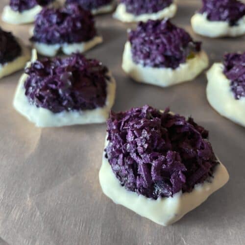 purple ube macaroons dipped in white chocolate.