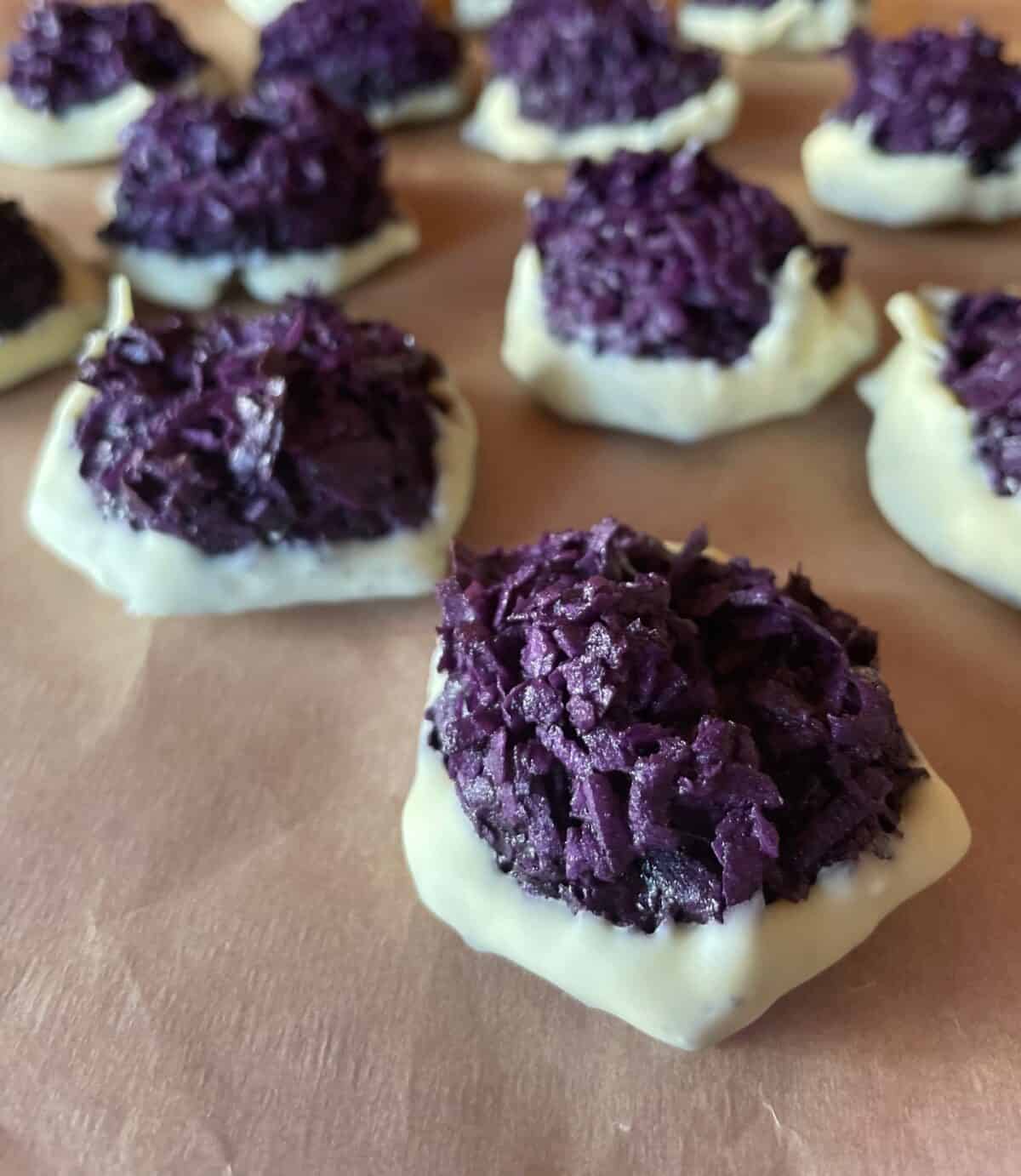 a picture of ube macaroons dipped in white chocolate