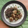 chicken and apple meatballs on a plate with quinoa, cooked mushrooms, and chopped parsley.