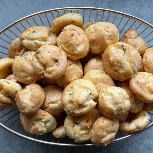 cheese bacon puffs filling up an oval wire bowl.