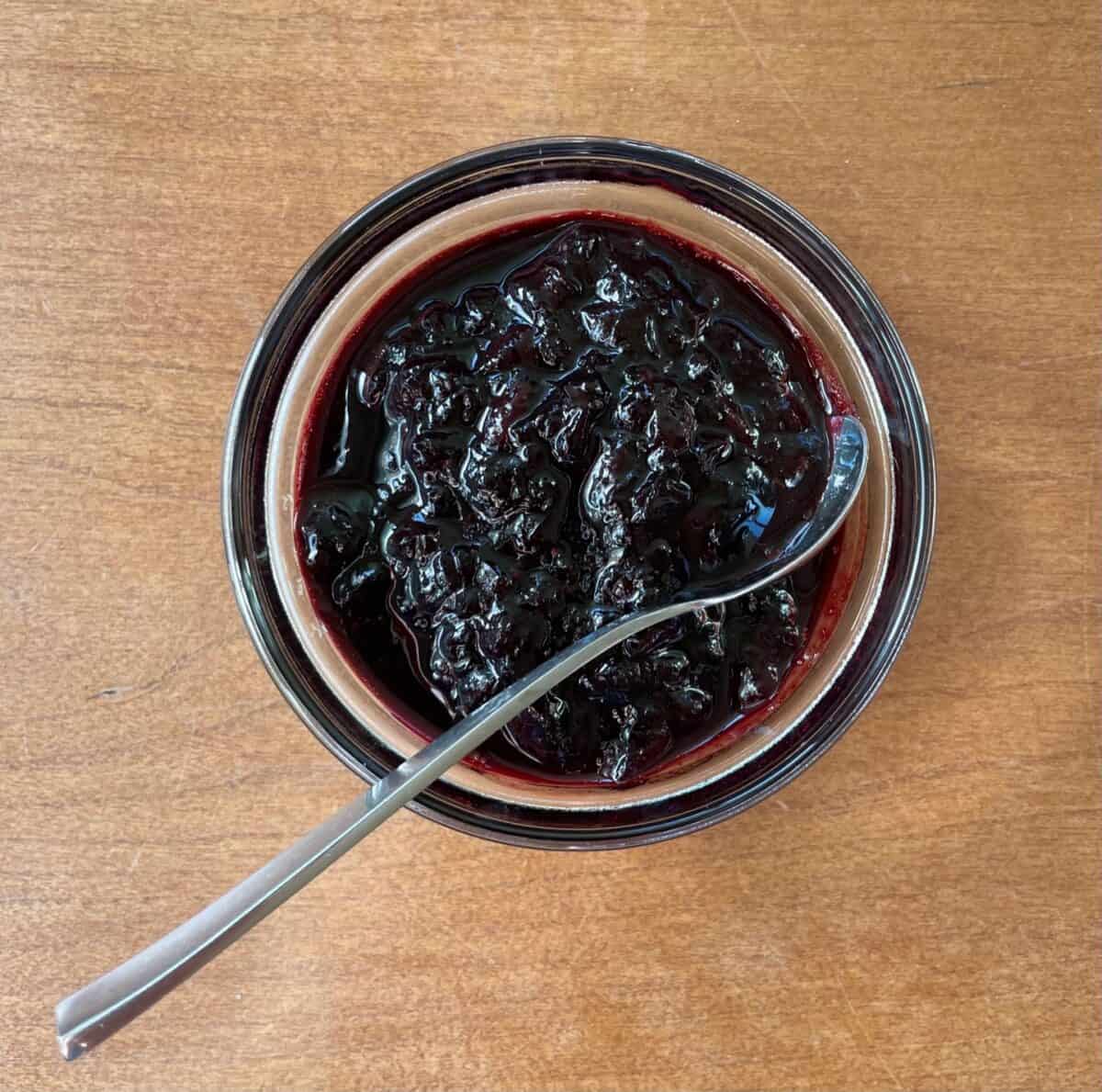 small bowl of cherry ketchup with a spoon.