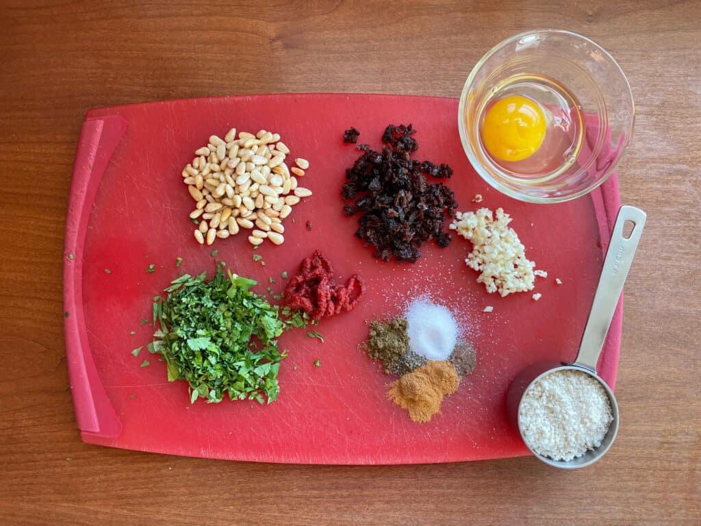 ingredients for lamb meatballs on a cutting board.