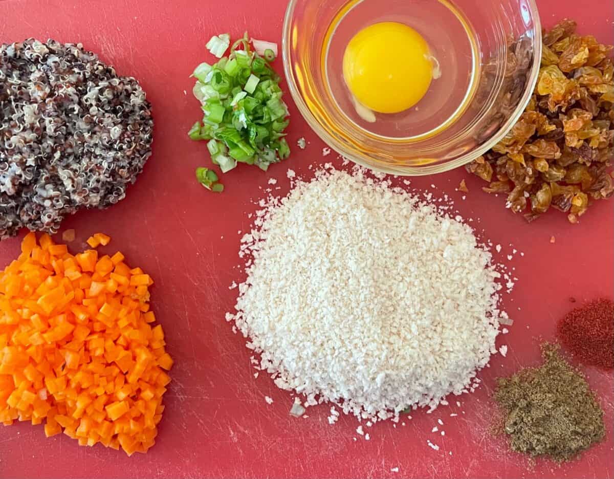 ingredients for cauliflower burgers including quinoa, carrot, egg, raisins, panko, herbs and spices.