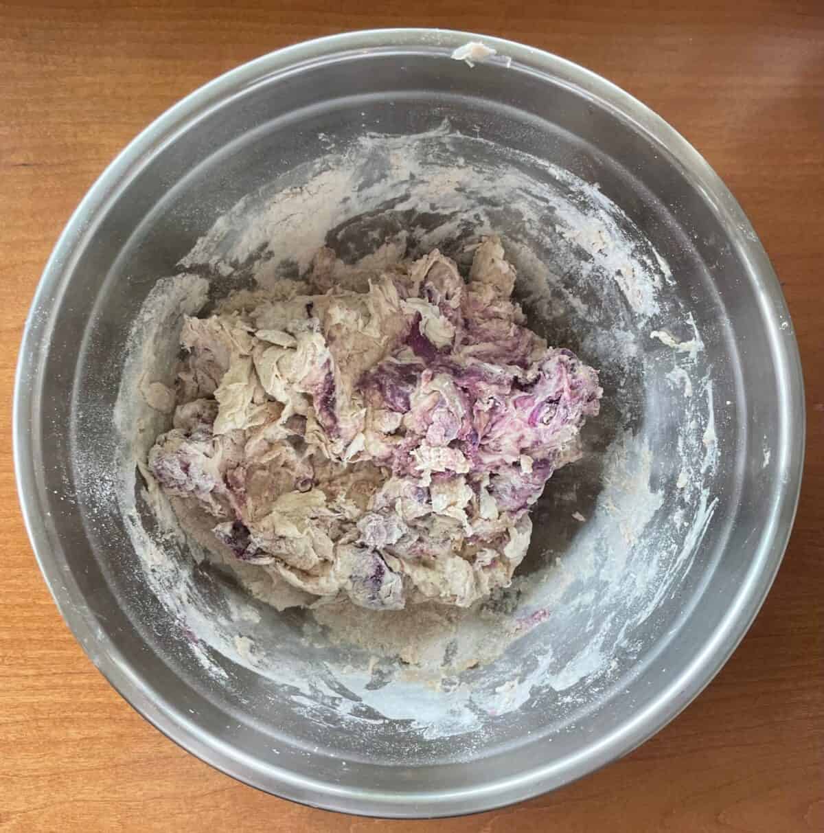 mixing bowl with flour and mashed purple sweet potato.