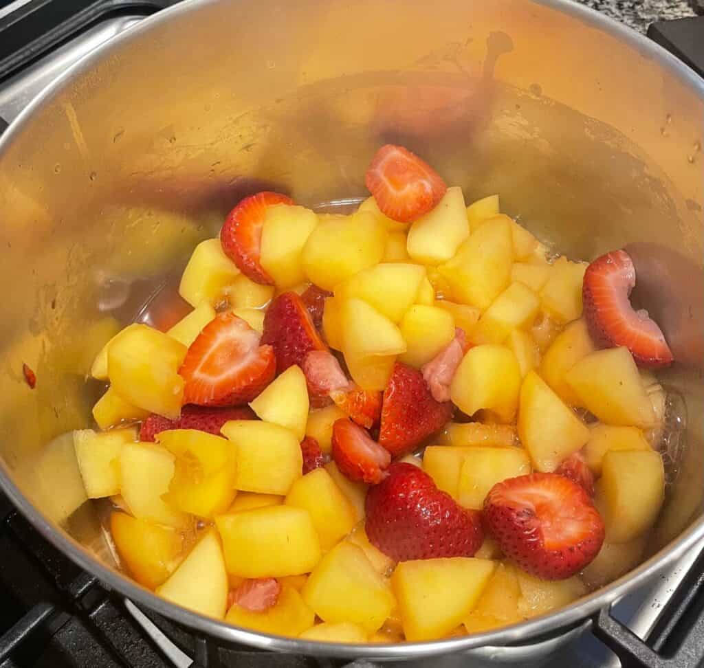 strawberries and apples in a pot.