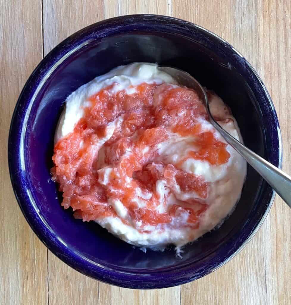 a bowl of yogurt topped with unsweetened strawberry applesauce.