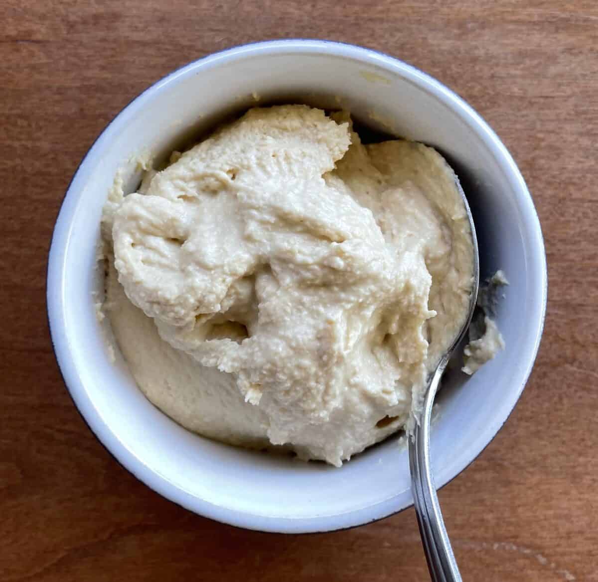 bowl of hummus with a spoon.
