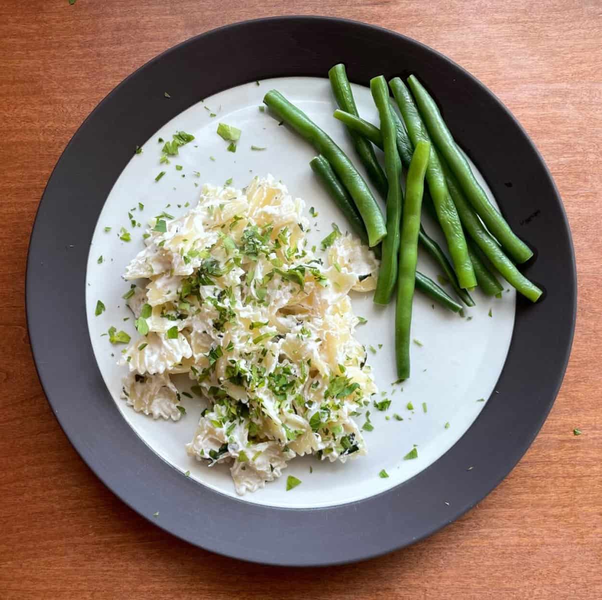 plate of ricotta and lemon pasta with green beans.