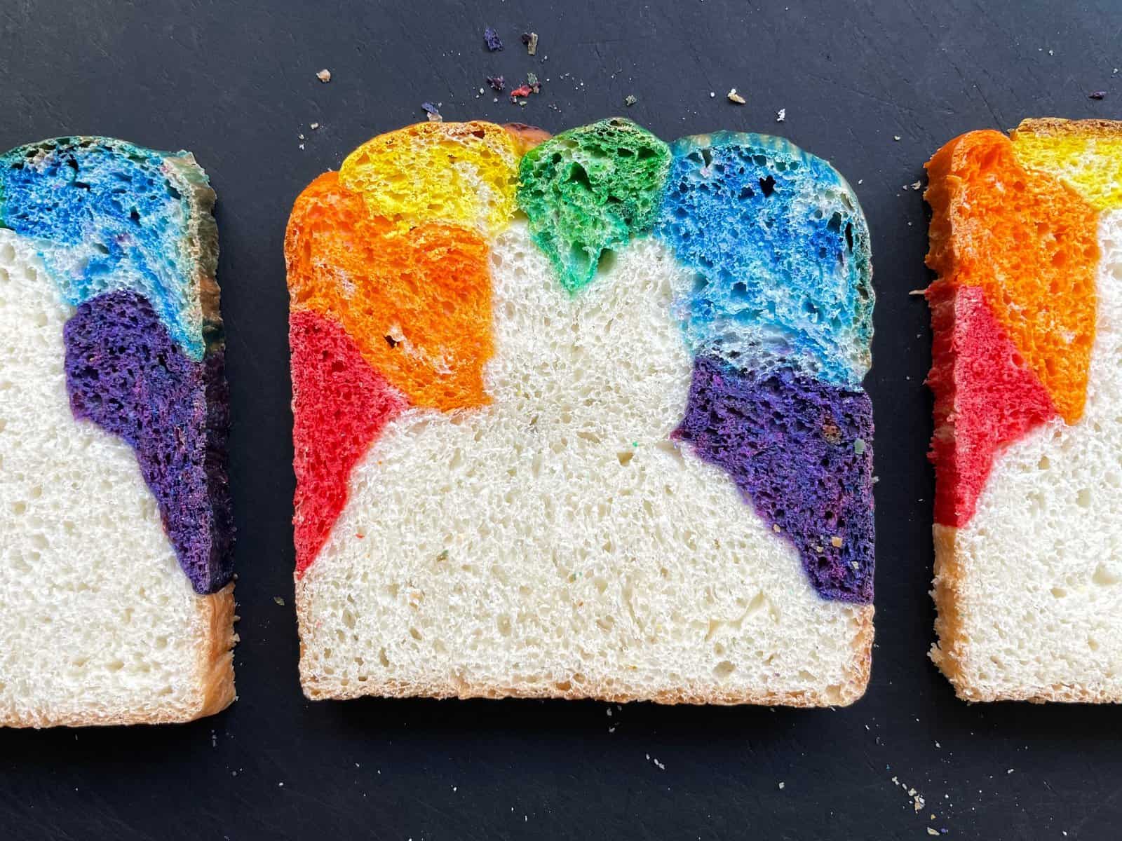 three slices of rainbow bread on a cutting board.