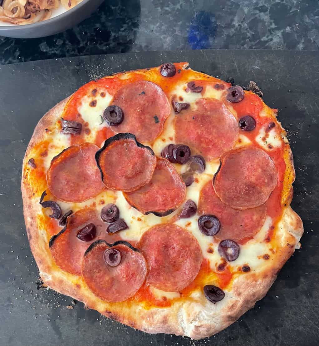 round pizza with pepperoni and olives.