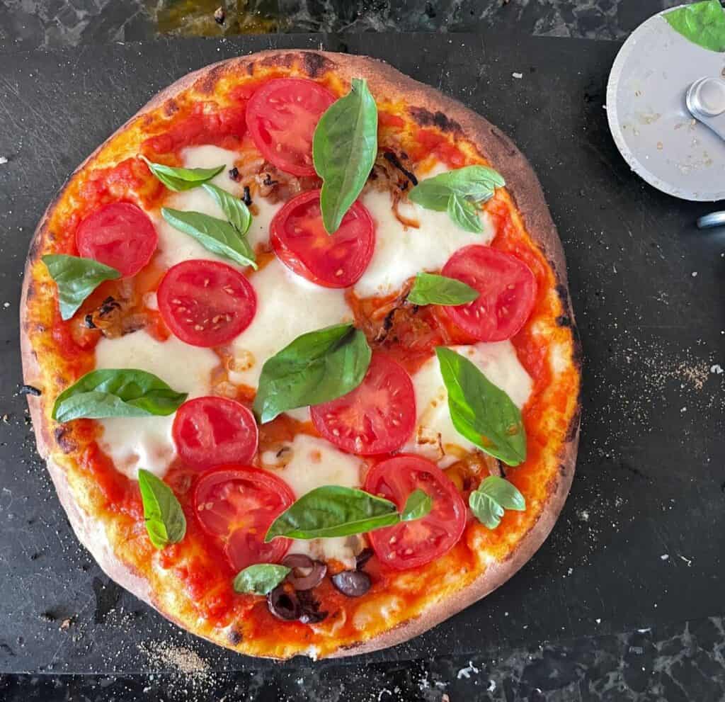 margherita pizza on a cutting board.