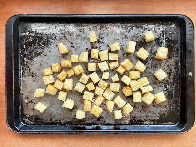 A baking sheet filled with sourdough croutons.