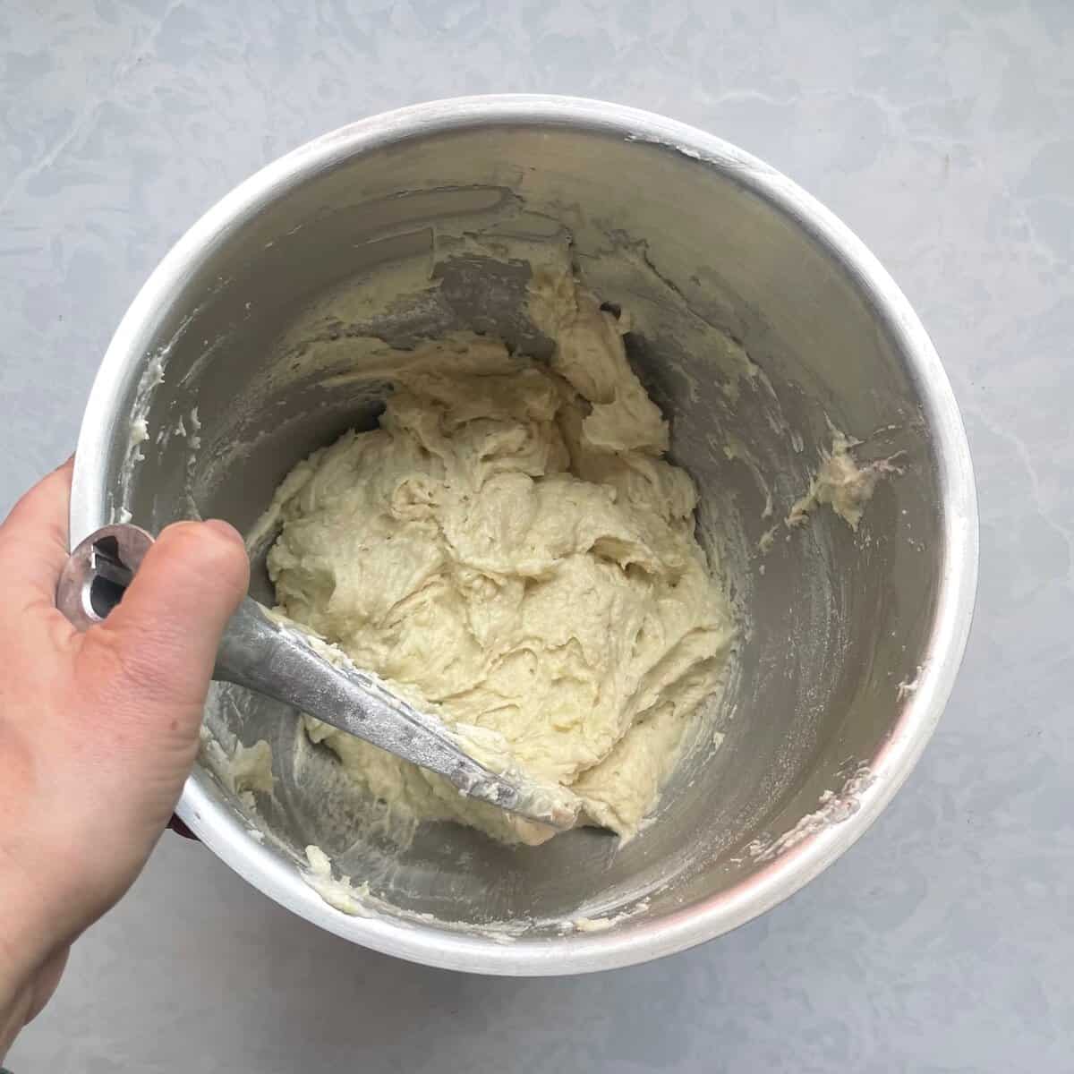 greenish lime cake batter in a mixing bowl with beater.