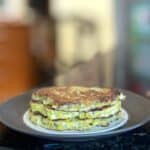 three fried patty pan squash platties stacked on a plate