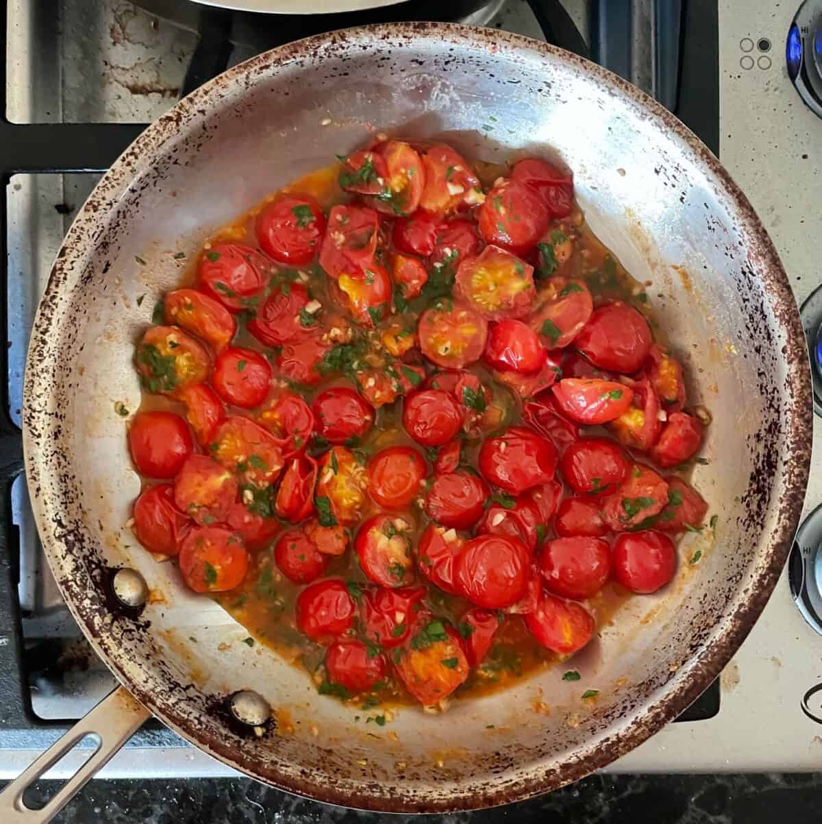 a frying pan full of lightly cooked cherry tomatoes.