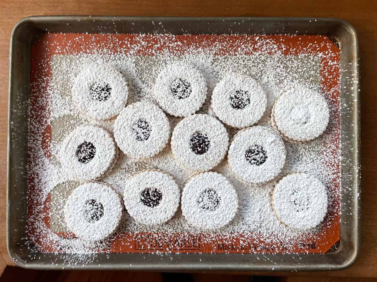 a tray of shortbread Linzer cookies covered with a dusting of confectioners sugar.
