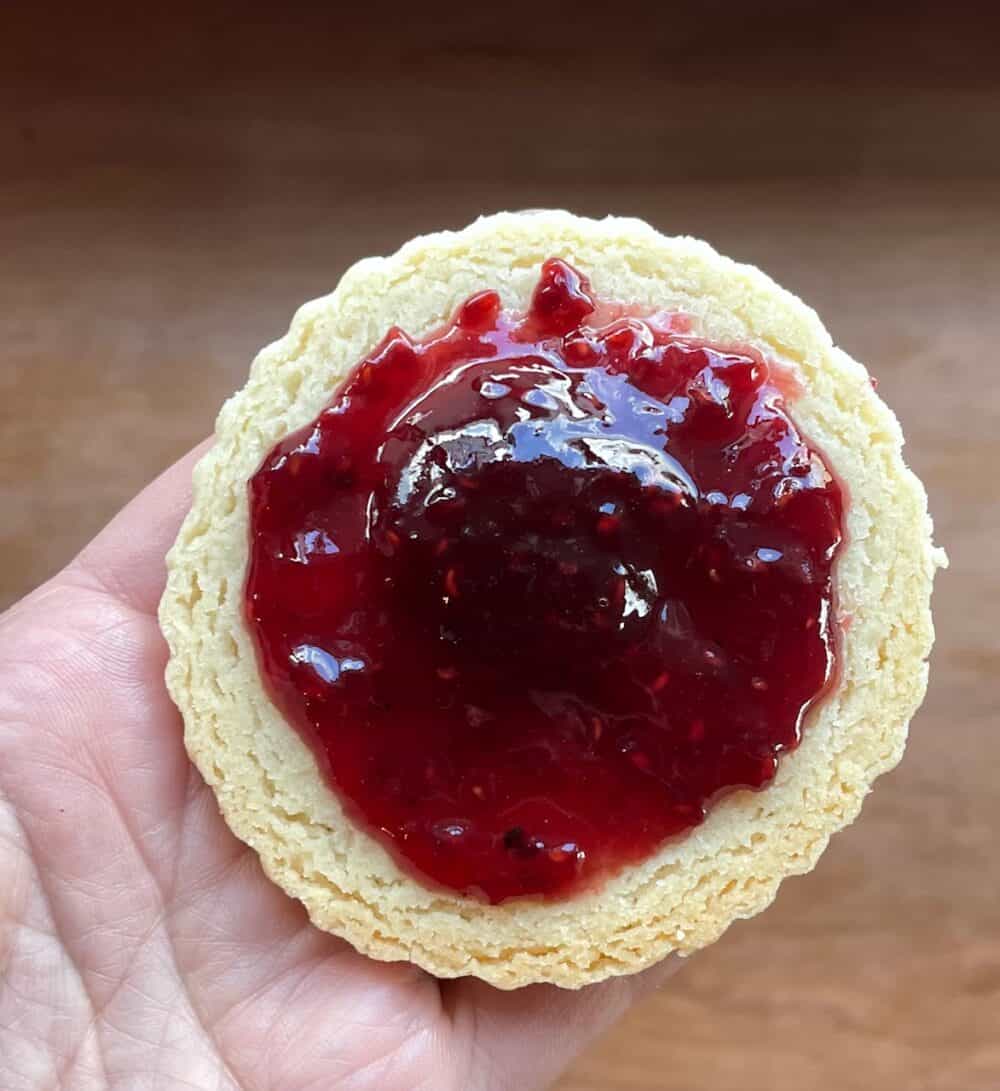 a bottom shortbread cookie with raspberry filling not quite to the edge.