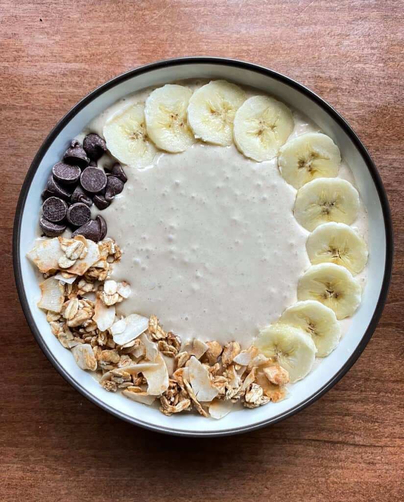 peanut butter banana smoothie bowl with banana, granola, coconut, and chocolate chips.