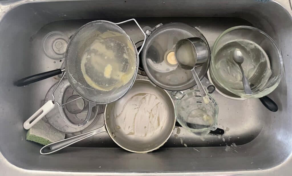 the mess of pans and dishes in the sink after making apple lemon curd.