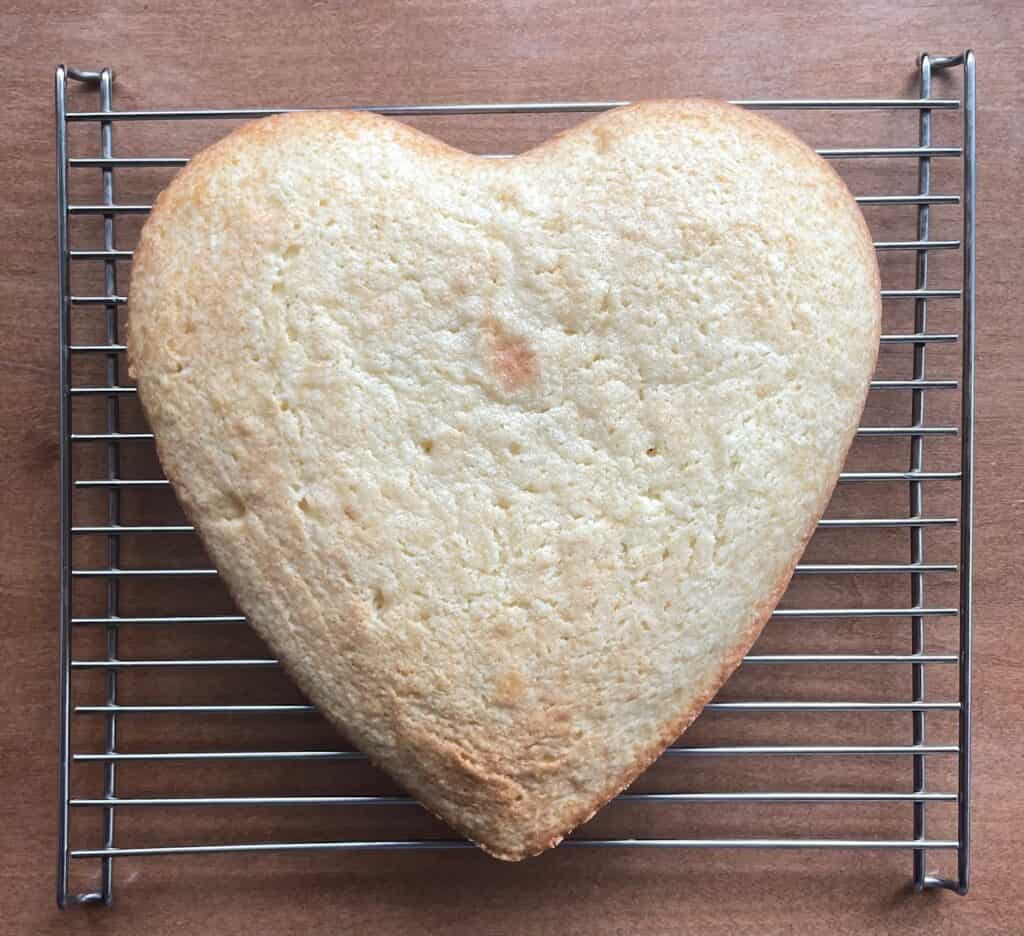 a heart-shaped cake on a cooling rack.