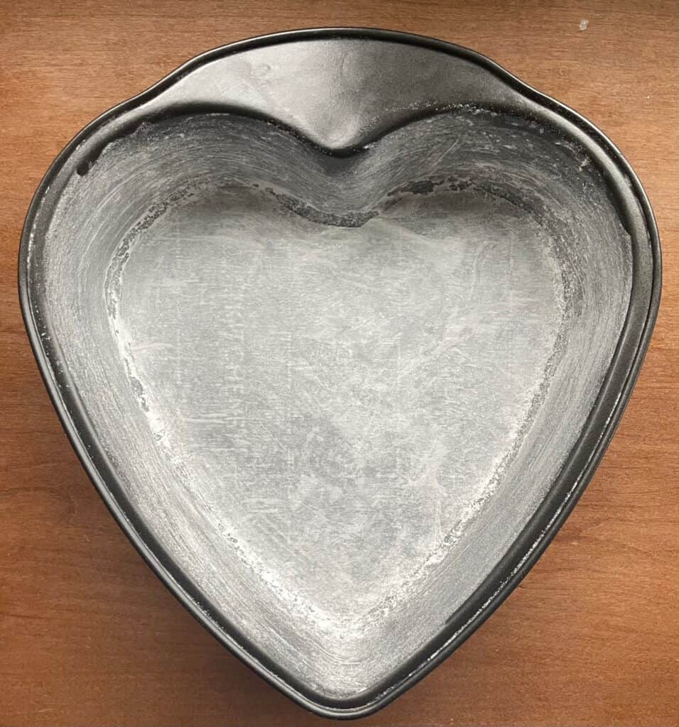 a heart shaped cake pan that has been buttered and floured.