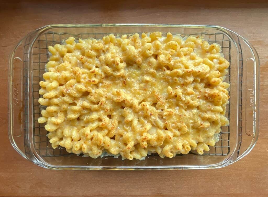 cavatappi mac and cheese baked in a glass pan.