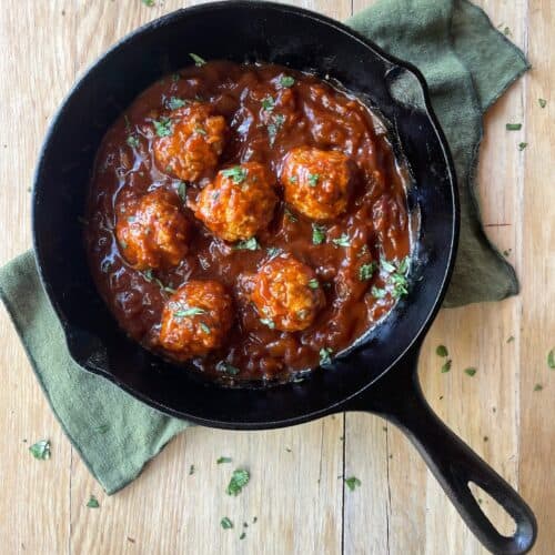 cast iron pan with chicken meatballs and barbecue sauce.