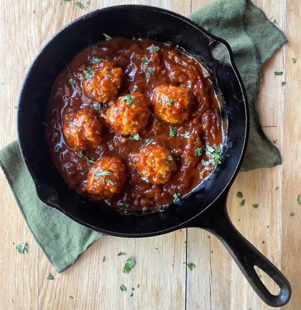 cast iron pan with chicken meatballs and barbecue sauce.