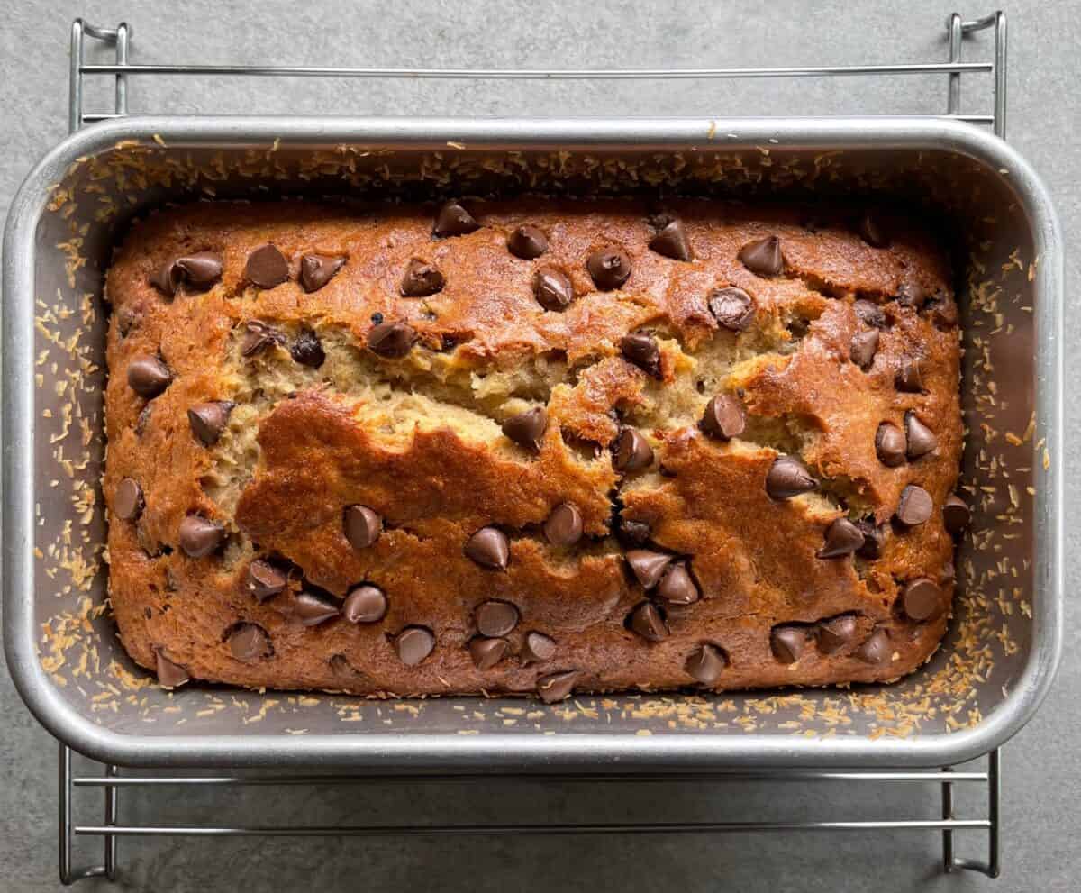 chocolate chip banana bread baked in the pan on a cooling rack.