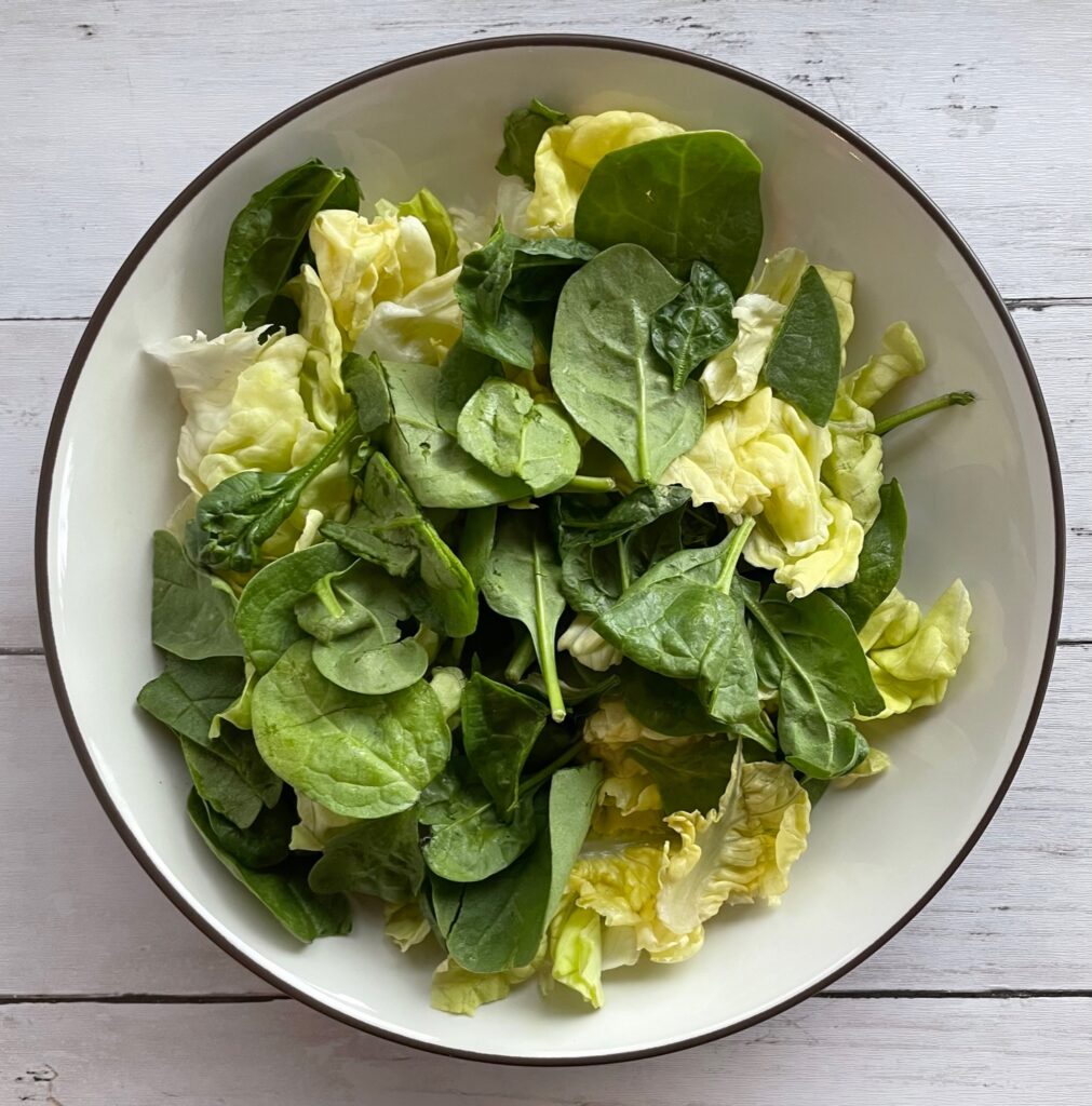 butter lettuce and spinach in a salad bowl.