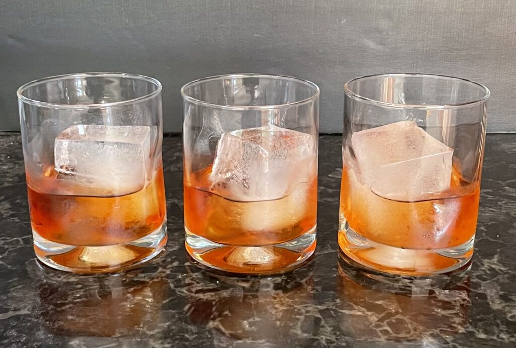 three rocks glasses with aperol negroni vermouth variations.