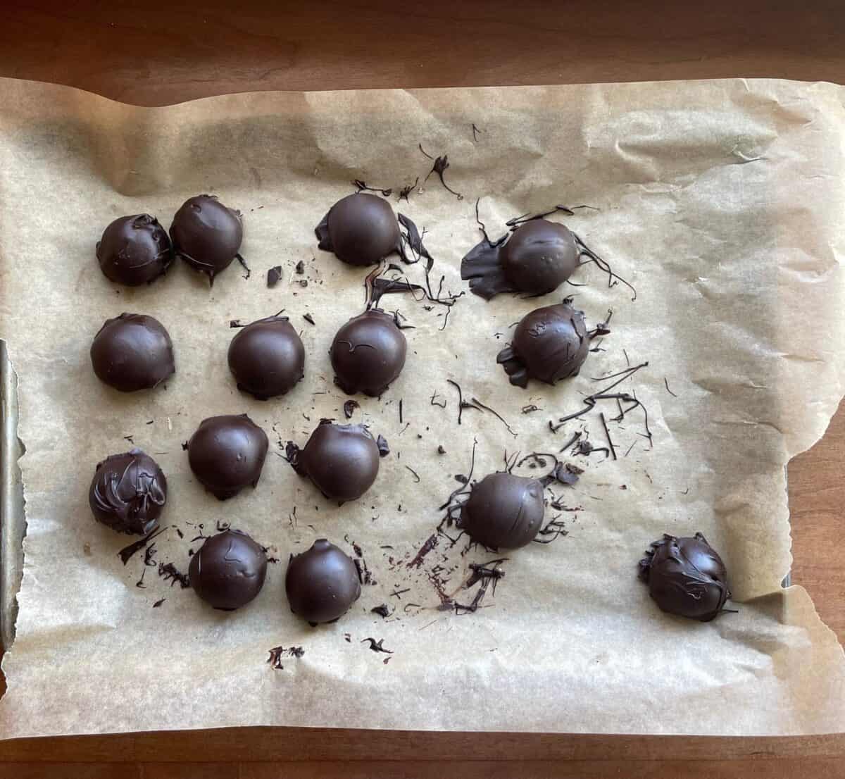 chocolate peanut butter bonbons on a parchment-lined tray.
