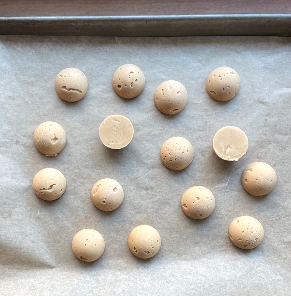 domes of peanut butter filling on a tray.