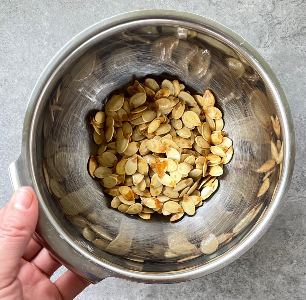 metal bowl filled with cleaned pumpkin seeds.