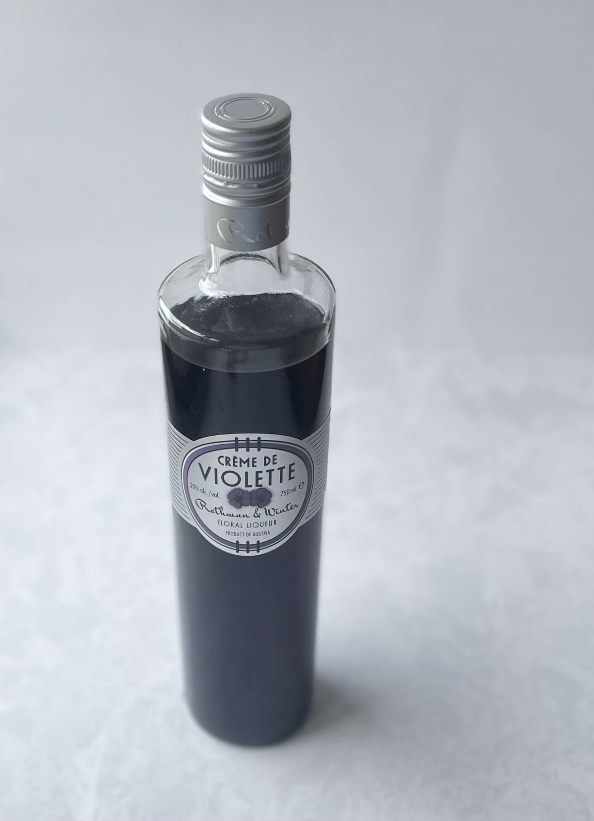 bottle of creme de violette on a white countertop.