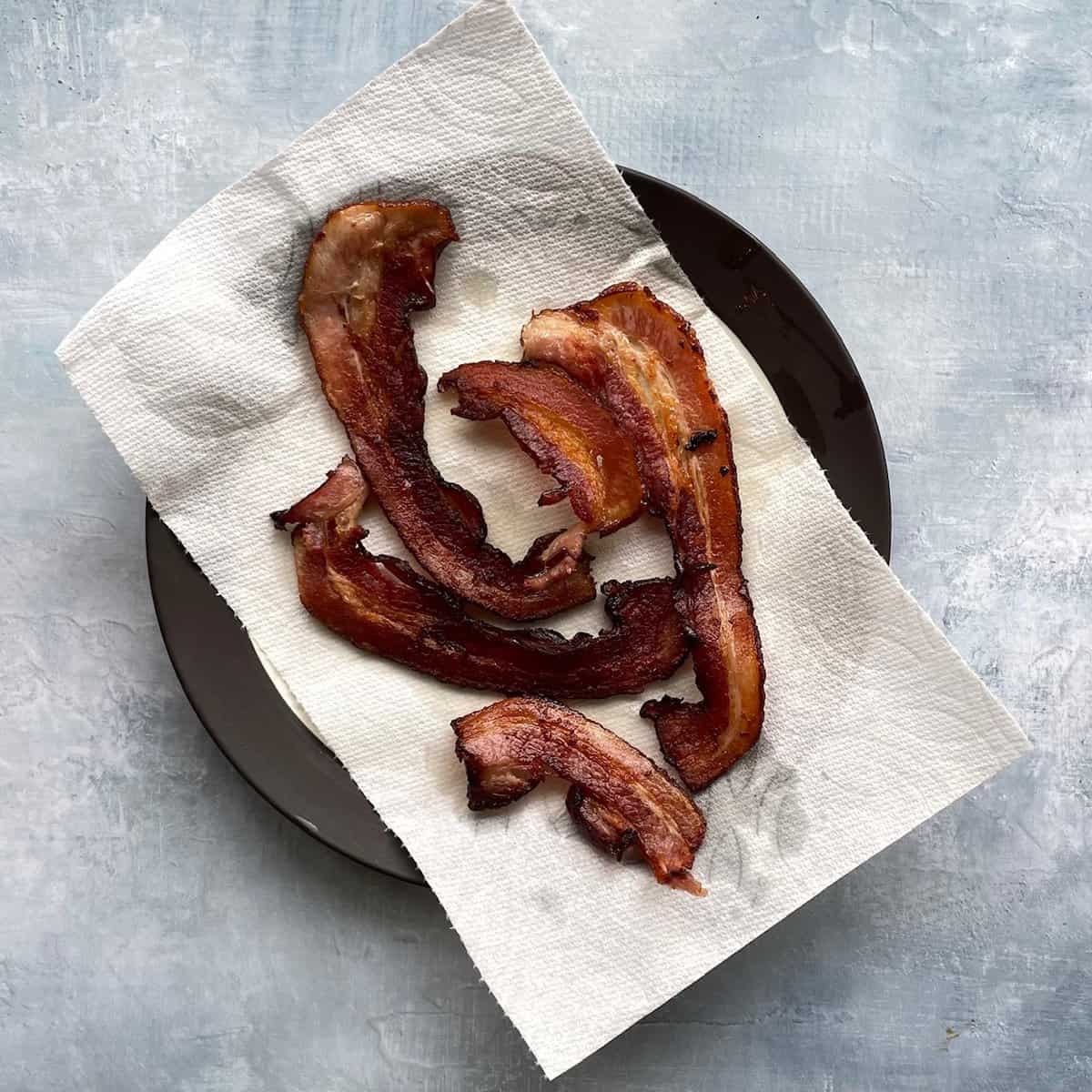 strips of bacon on a paper-towel lined plate.